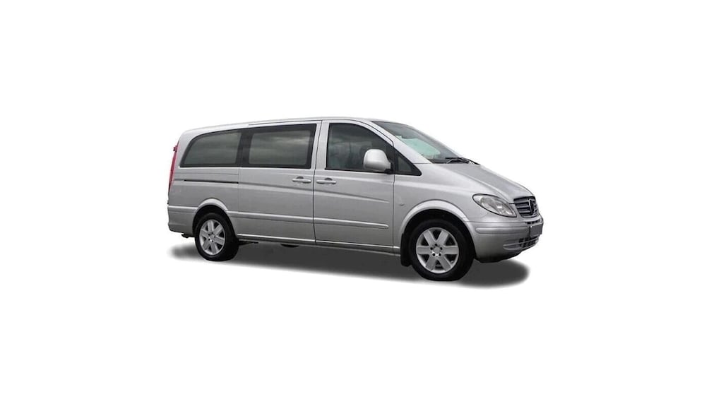 A silver minivan with a visible side mirror, windows, and wheels. 1