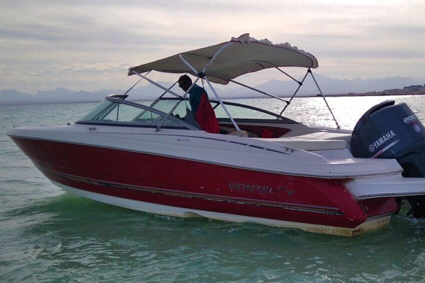 A red and white speedboat with a Yamaha motor on calm water. 3