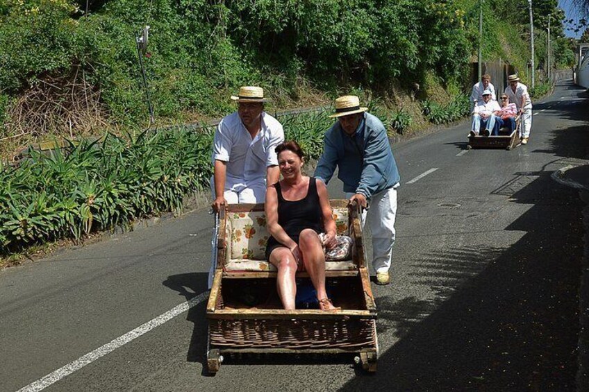 Une personne en fauteuil roulant est poussée par deux personnes sur une route bordée de verdure. 5