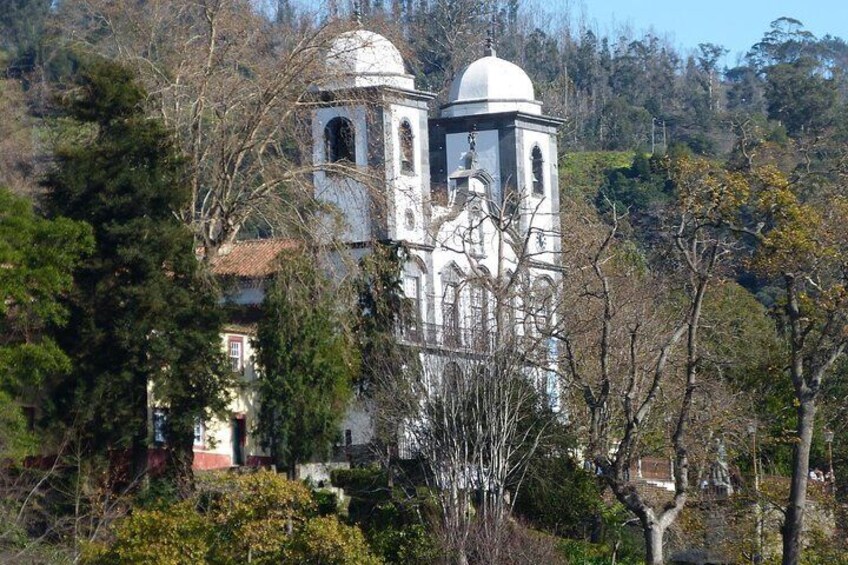 Une église blanche, dotée de deux coupoles, entourée d’arbres. 2