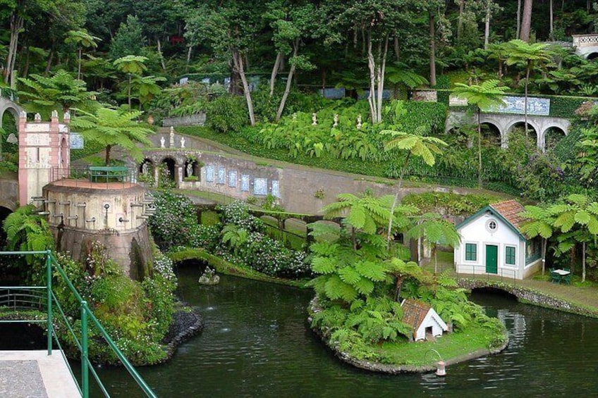 Un jardin avec un pont, une petite maison et une structure qui ressemble à un château. 4