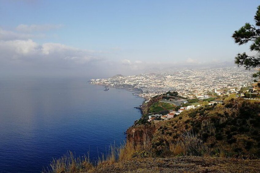 Un paysage urbain côtier offrant une vue dégagée sur la mer et une zone vallonnée parsemée de bâtiments. 4