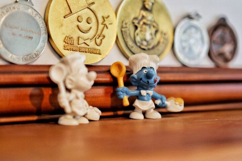 A collection of medals and figurines on a wooden surface. 4