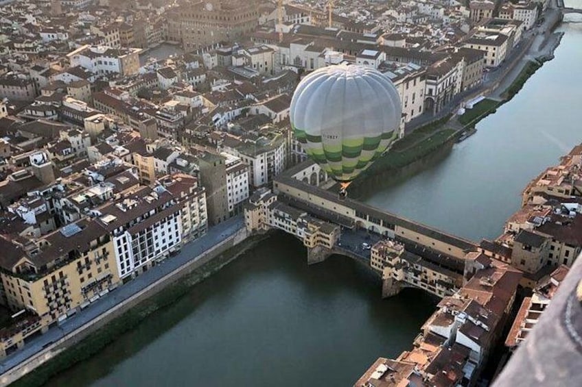 Eine Heißluftballonfahrt über einem Fluss in einer Stadt mit Gebäuden und einer Brücke. 1