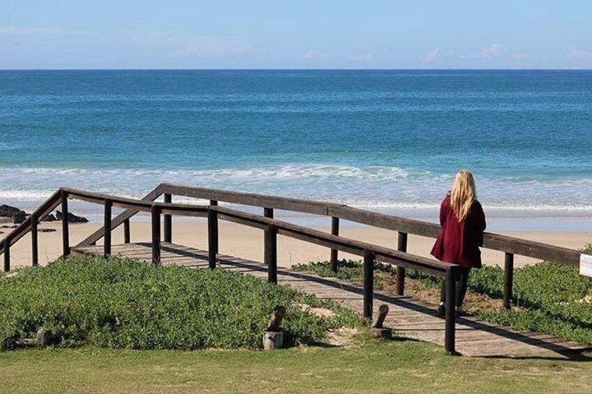 A wooden boardwalk leading to a beach with ocean waves. 2