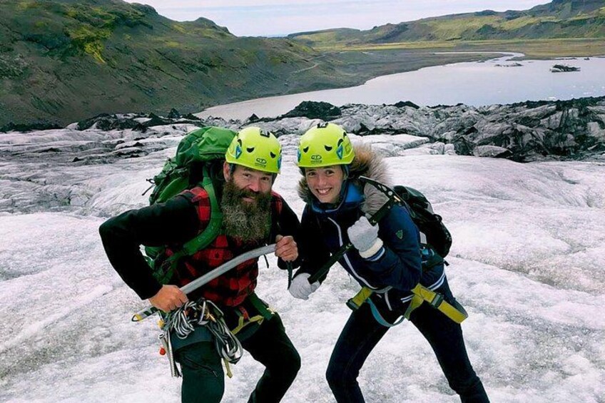 Two people hiking on a glacier with backpacks and helmets. 5