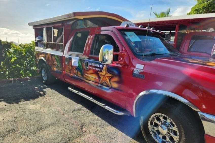 Camión rojo con una estrella y texto en la carrocería, estacionado en un camino de tierra. 2