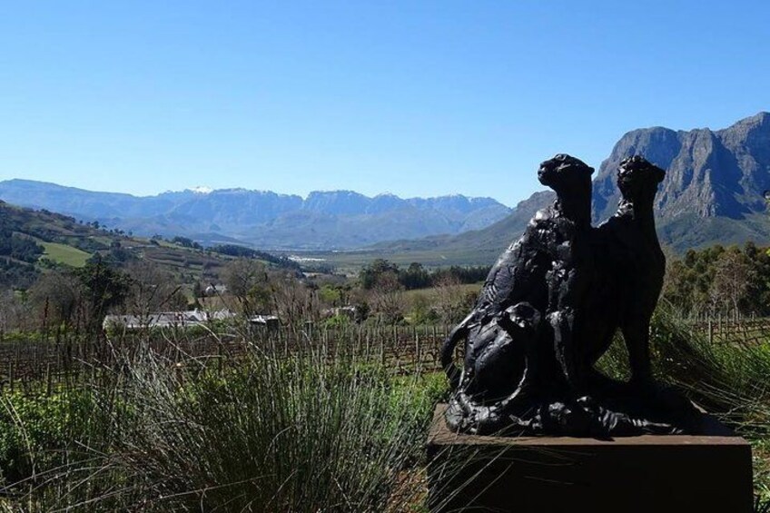 Una escultura de dos perros en un campo con montañas al fondo. 4
