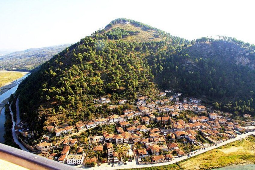 A coastal village with houses built along the shoreline, surrounded by hills and a river. 1