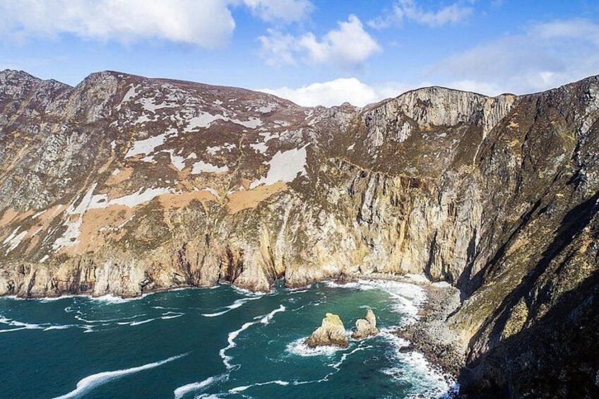 Paisaje montañoso costero con acantilados rocosos y una masa de agua. 4