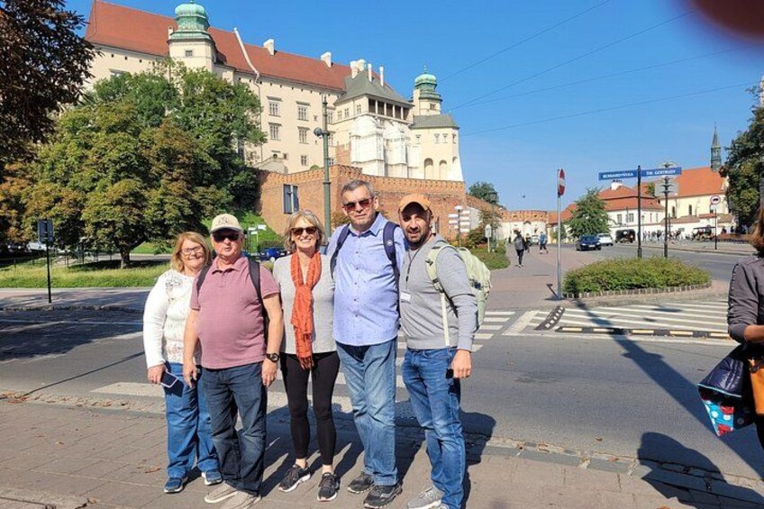 Un grupo de personas de pie en una acera con un edificio histórico al fondo. 5