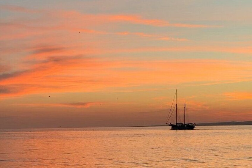 A sailboat on calm water during sunset. 5