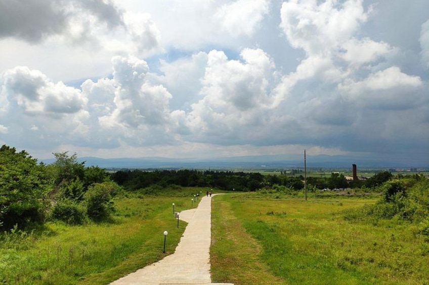 Een verhard pad door een grasveld onder een bewolkte lucht. 2