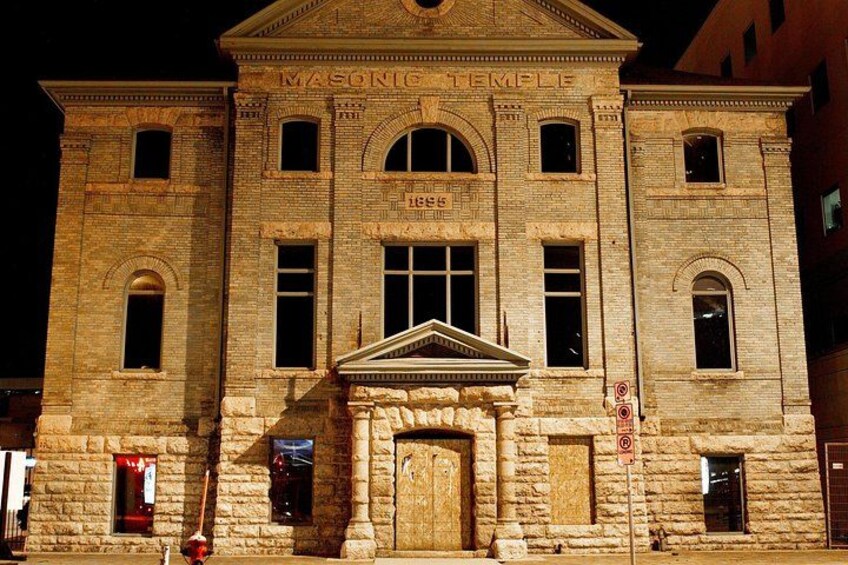 Un bâtiment historique dont la façade porte l’inscription « Temple maçonnique » et l’année « 1895 ». 5