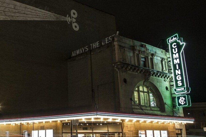 Un théâtre avec une enseigne lumineuse indiquant « CUMMINGS » et une affiche au-dessus de l’entrée sur laquelle on peut lire : « TOUJOURS LE MEILLEUR ». 3
