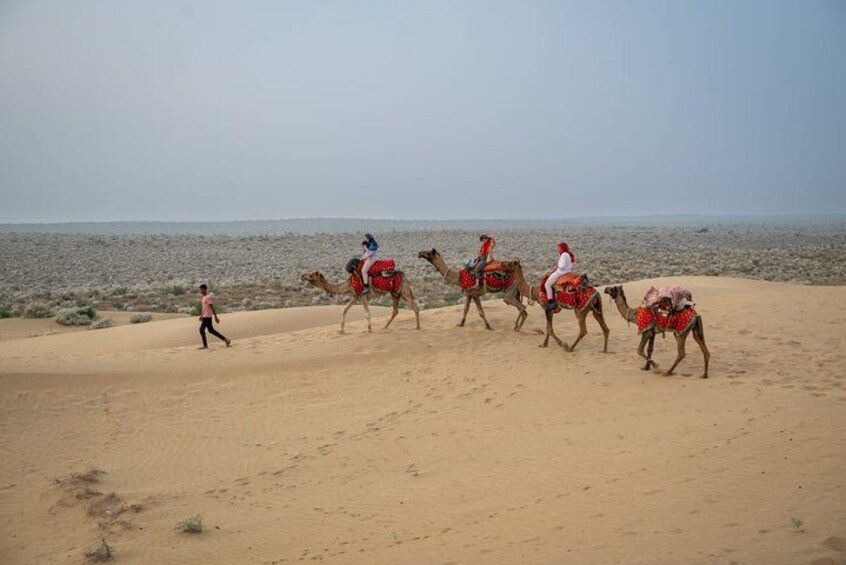 A desert landscape with camels and riders. 1