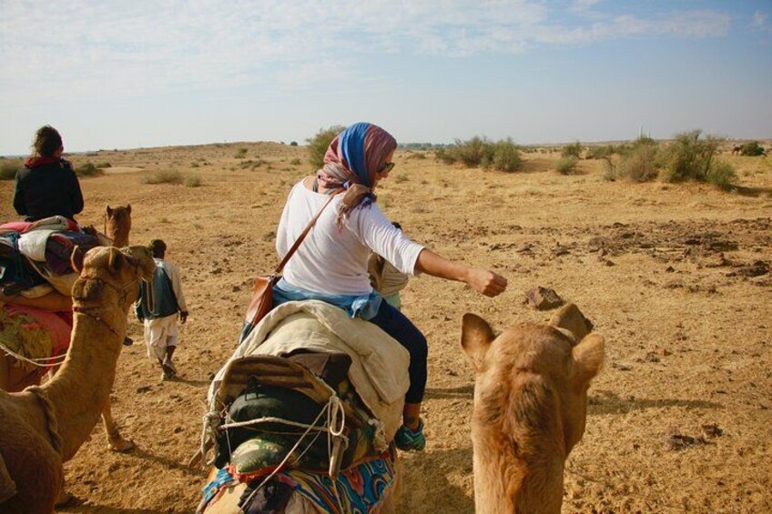 A person riding a camel in a desert landscape. 4