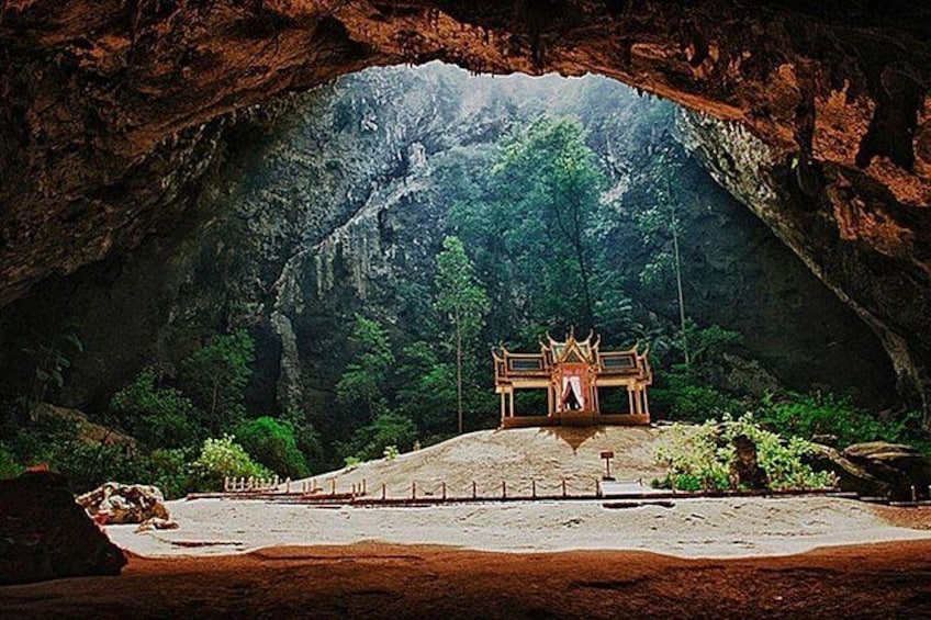 Una cueva con una estructura de templo en su interior, rodeada de abundante vegetación. 1