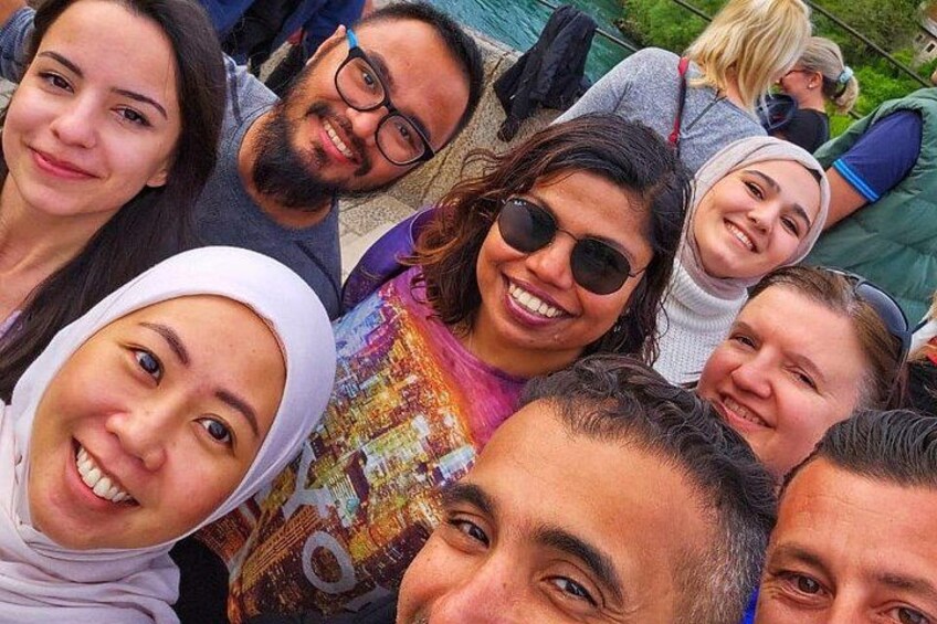 A group of people outdoors, some wearing casual clothing and one in a patterned shirt. 5