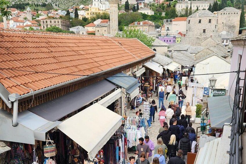 A crowded market street with shops and people. 3