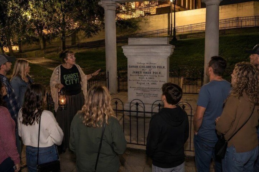 A group of people gathered around a monument at night. 1