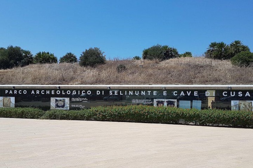 Señal para el Parco Archeologico di Selinunte e Cave di Cusa, con cielo despejado y hierba seca al fondo. 4