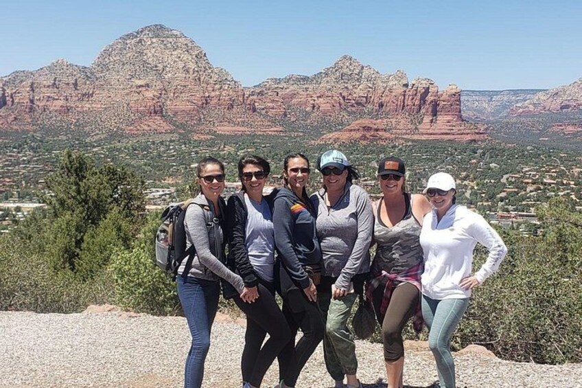 A group of people standing on a hill with a mountainous landscape in the background. 5
