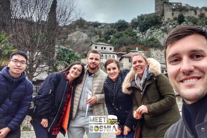 A group of people standing outdoors with a historical building in the background. 2