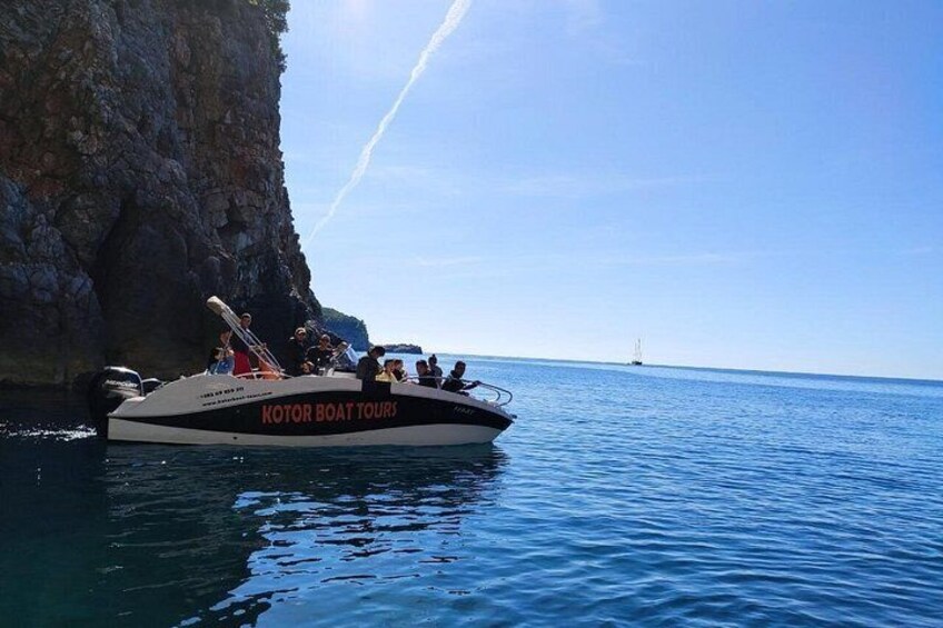 Un bote llamado 'KOTOR BOAT TOURS' sobre aguas azules tranquilas cerca de un acantilado rocoso. 3