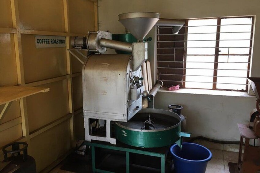 A coffee roasting machine, a blue bucket, and a window with bars. 2