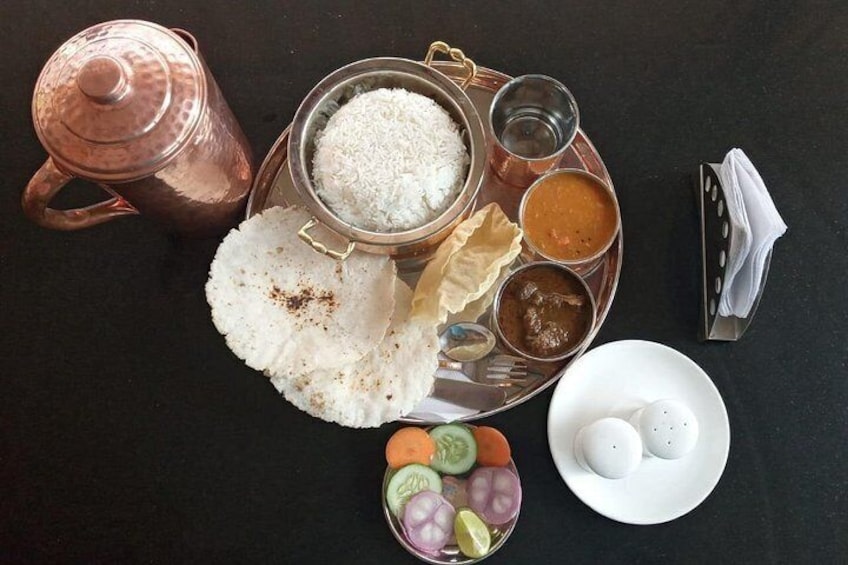 Un repas composé de riz, de curry et d’une marmite en métal, le tout sur une table. 3