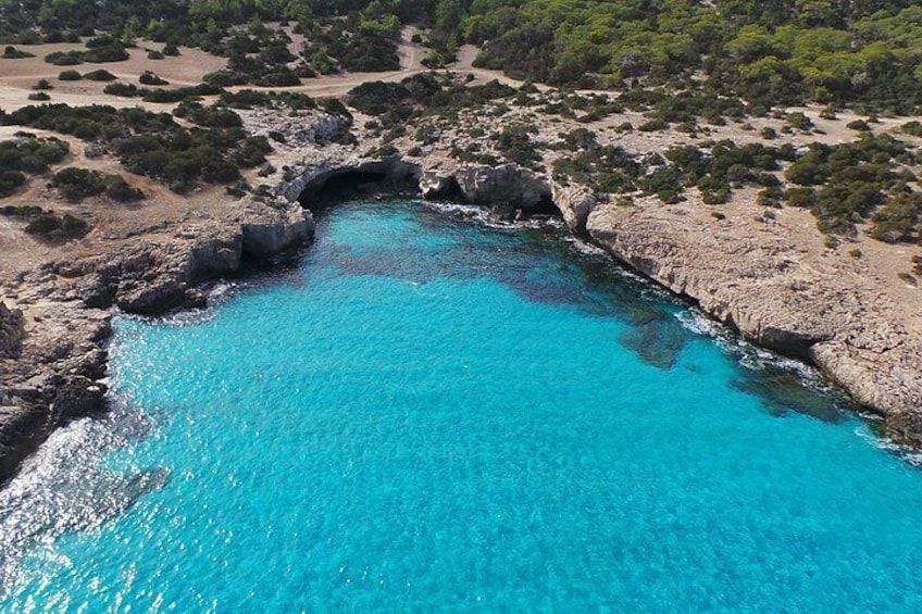 Una bahía costera turquesa con costas rocosas y vegetación escasa. 3