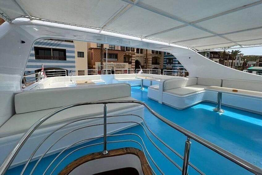 Eine Yacht mit Swimmingpool, weißen Liegestühlen und einem überdachten Bereich. 2