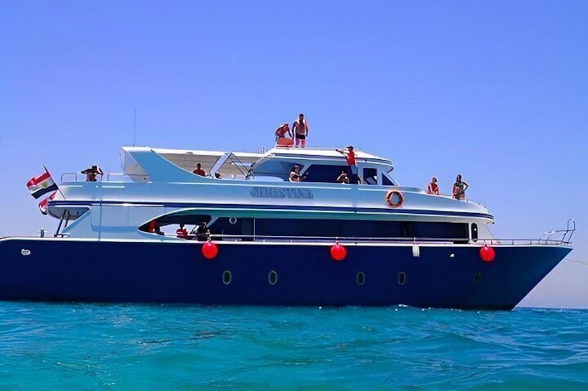 Eine große Yacht mit mehreren Decks, auf denen Passagiere das Meer genießen. 3