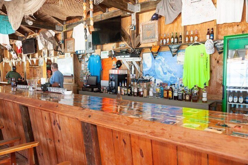 A rustic bar with wooden shelves, a green door, and various bottles. 4
