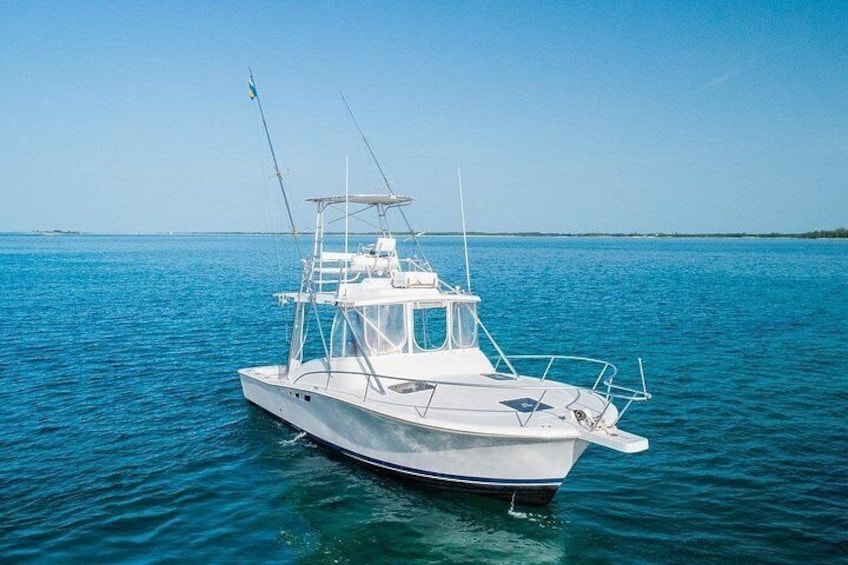 A white boat on calm blue water with a clear sky. 2