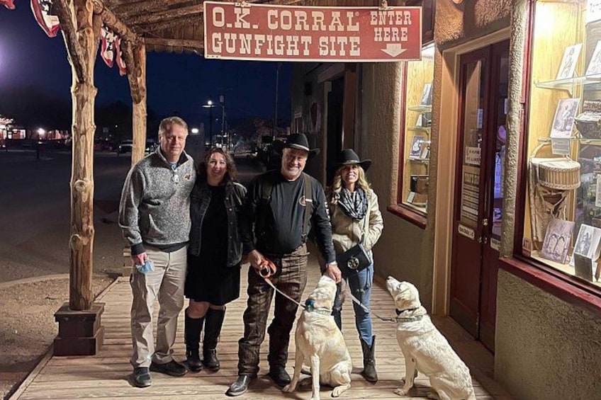 A group of people standing in front of a building with a sign that reads 'O.K. Corral Gunfight Site.' 5