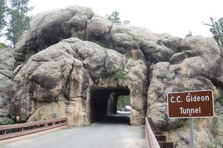 A rocky tunnel entrance with a sign reading 'C.C. Gideon Tunnel'. 2