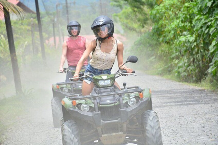 Dos personas paseando en cuatrimotos por un camino de grava rodeado de vegetación. 2