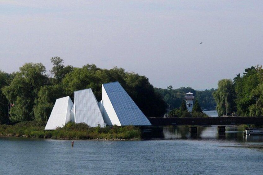 A river with a bridge, a white building with a sloped roof, and a tower in the background. 2