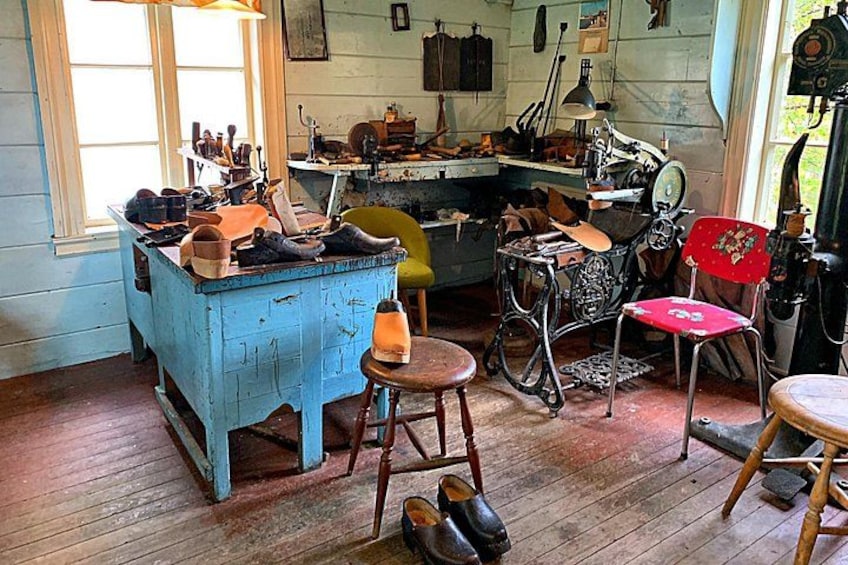 A vintage workshop with wooden furniture, a sewing machine, and various tools. 5