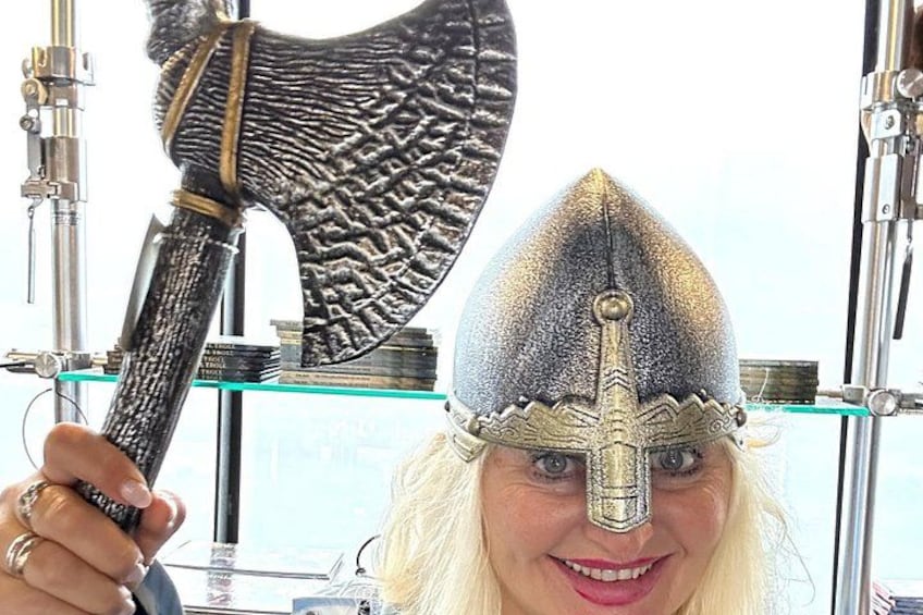 A person holding a large axe with a pointed head and a helmet with a pointed crest. 1