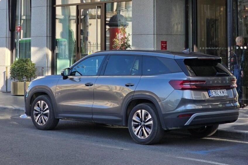 A silver SUV parked on a city street. 2