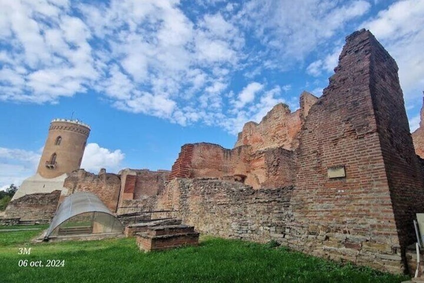 Ancient brick ruins with a tower and a grassy area. 1