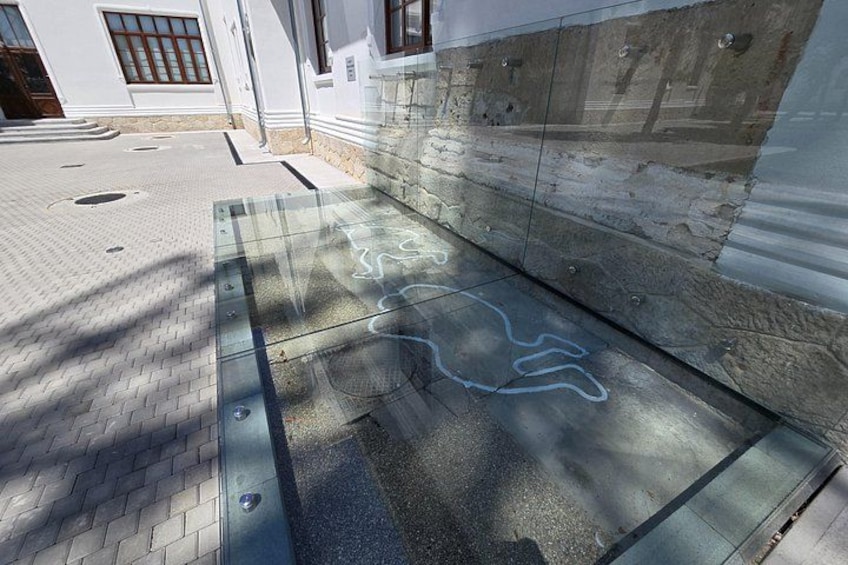 A sidewalk with a glass panel and a concrete wall. 2