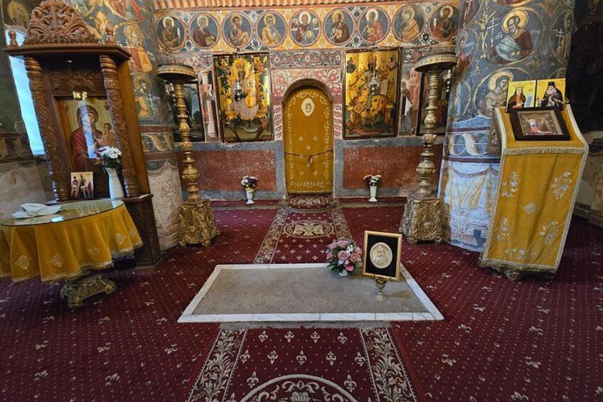 An ornate church interior with religious icons, a pulpit, and a red carpeted floor. 4