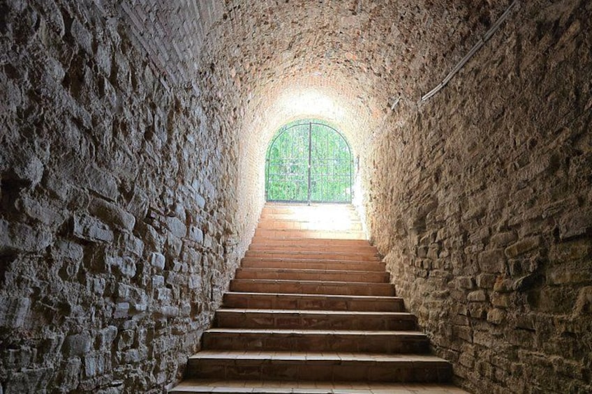 A stone staircase leading to a green arched window. 2