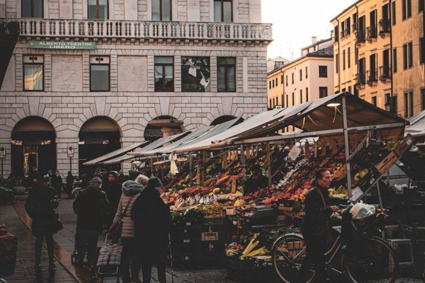 Un marché animé en plein air, où les gens font leurs courses et où les vendeurs proposent des fruits et des légumes. 2
