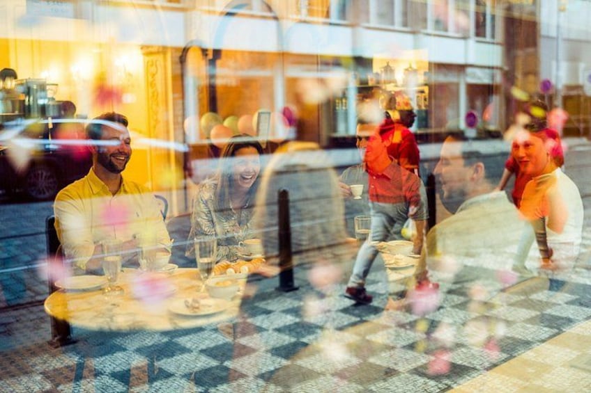 Des personnes dînent dans un restaurant en plein air, à une table recouverte d’une nappe à carreaux. 2
