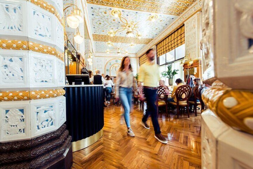 Un salón imponente con techo ornamentado y suelo de parqué de madera. 2